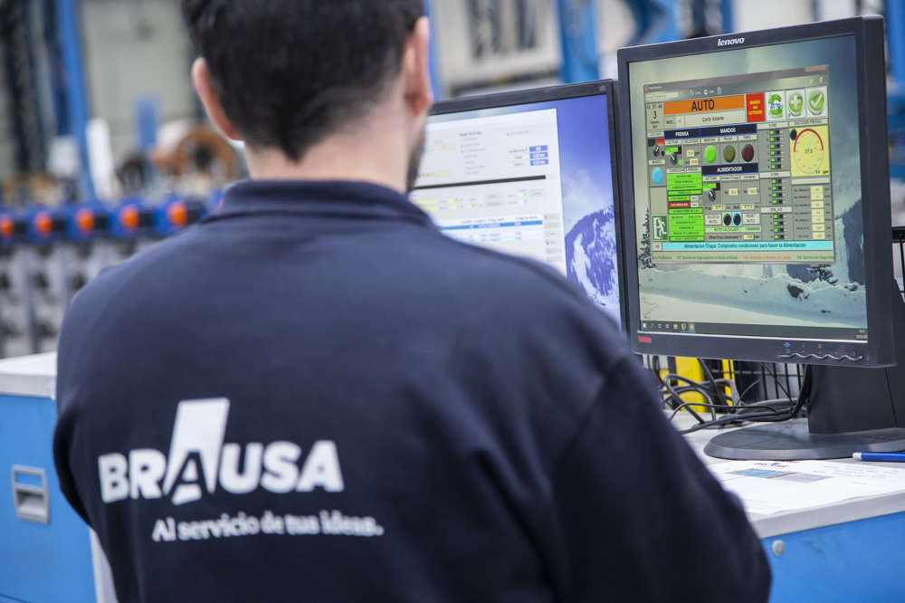 Foto operario técnico con máquina de producción de perfiles de acero conformados en frío de Brausa